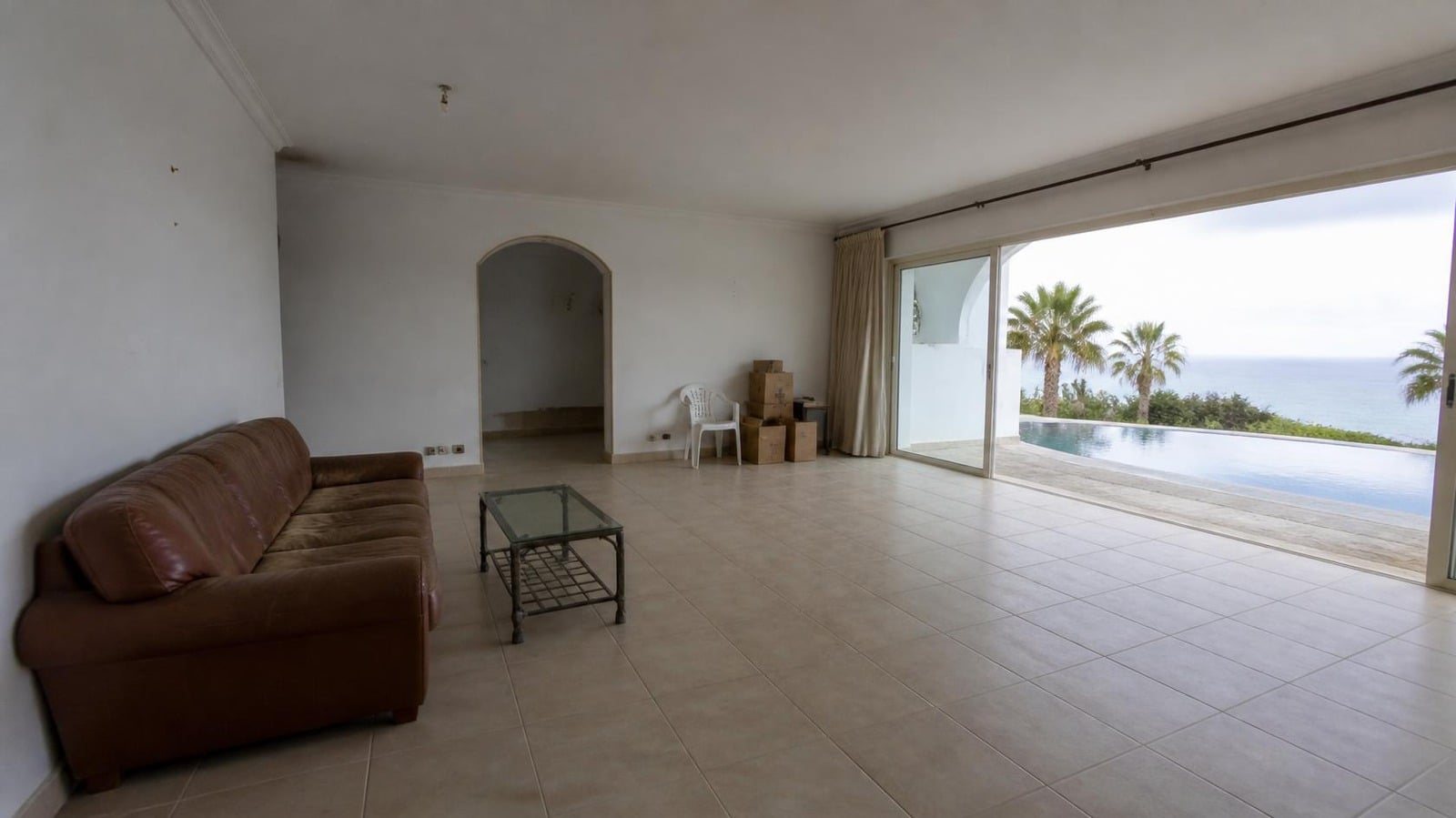 Salón de una villa en Marbella antes de decorar, con muebles viejos y cajas